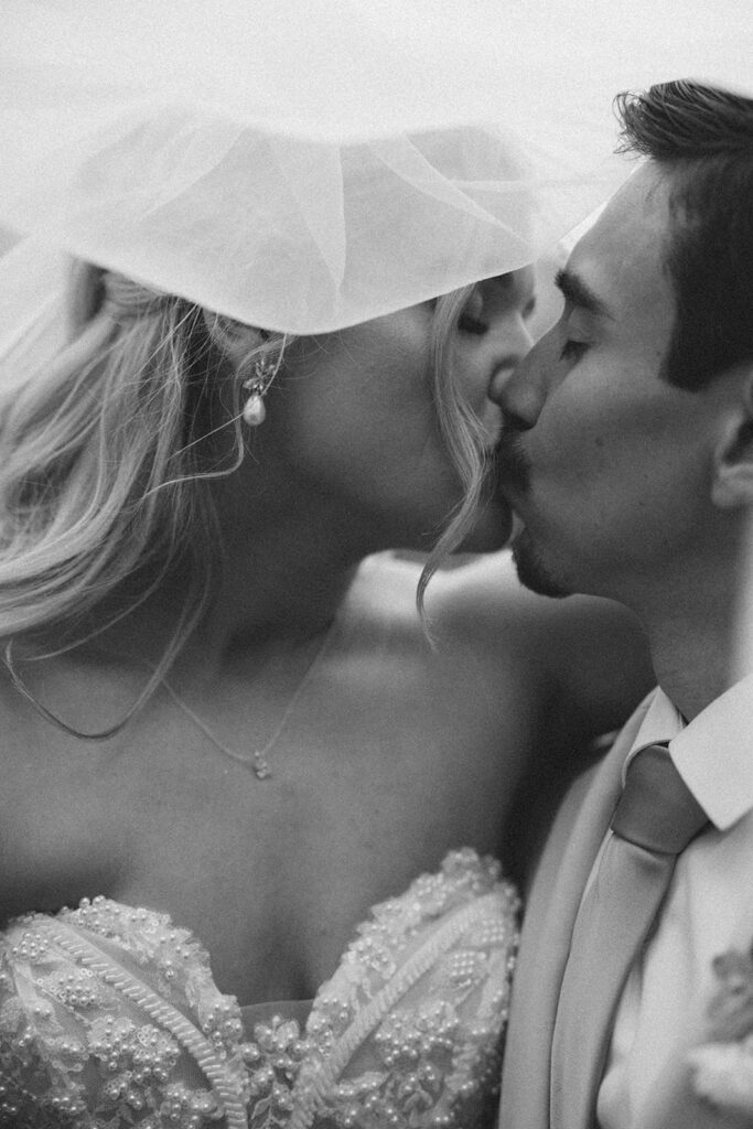 Bride and groom kissing romantically. 