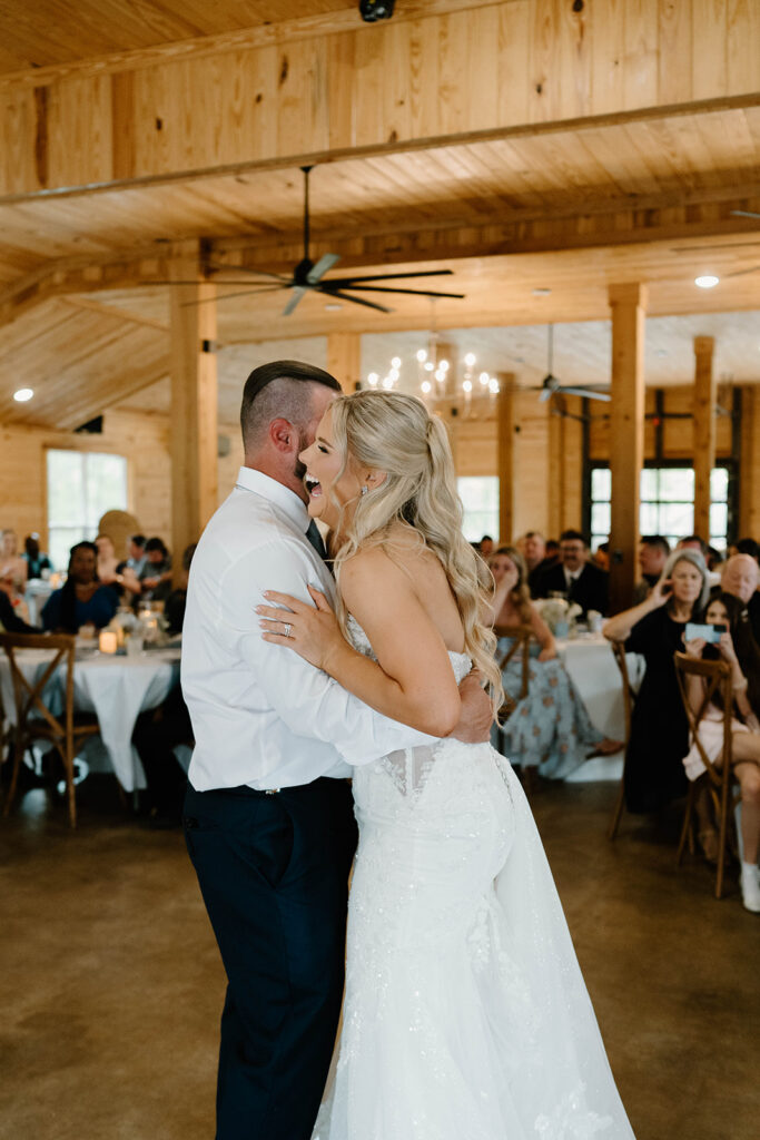 Bride laughing while dancing with her dad for candid wedding photos.