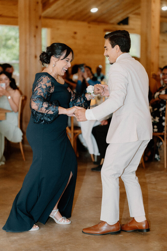 Mother of the groom dancing with her son happily. 