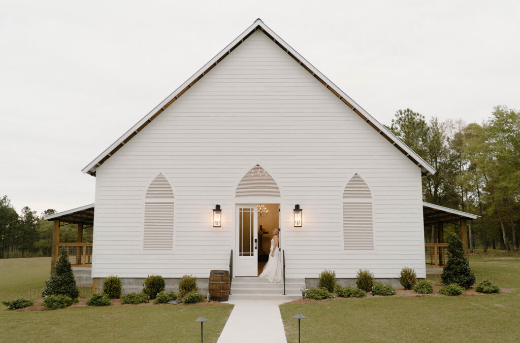 The bride in the doorway of the white chapel at Mount Pleasant Lodge.