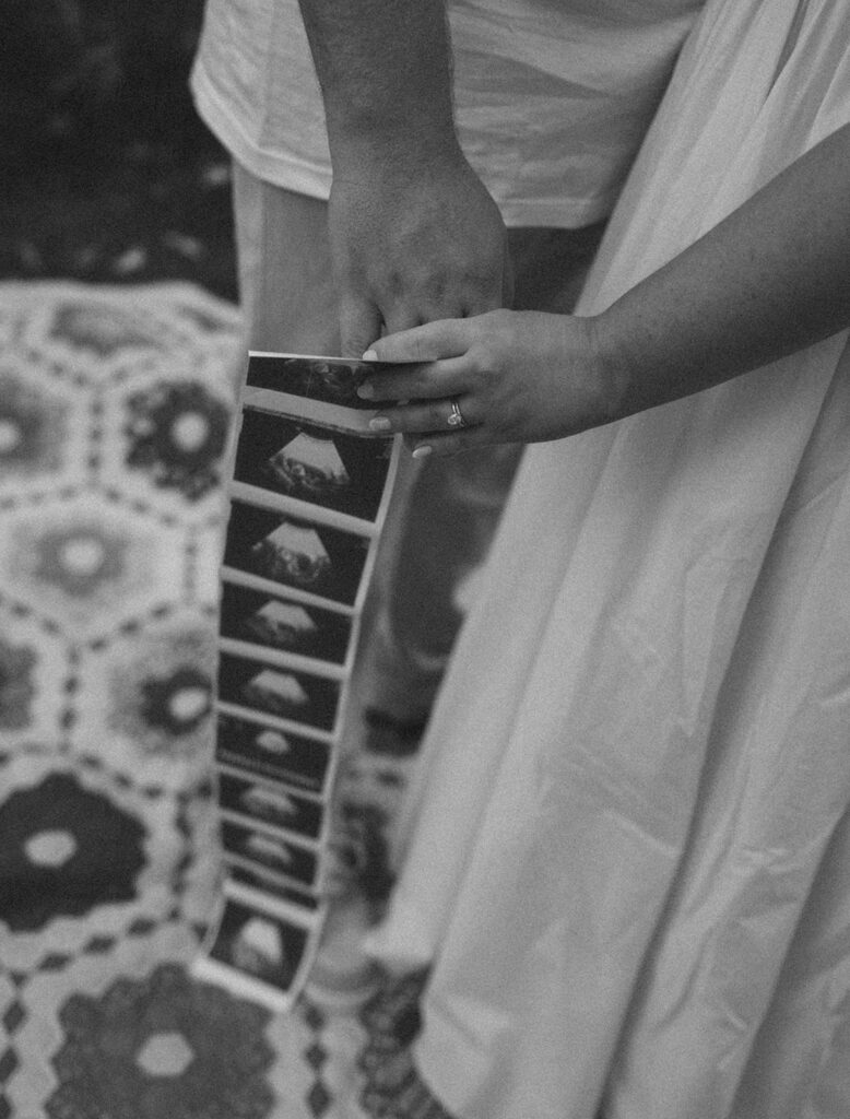 Pregnancy announcement photos of a couple holding an ultrasound photo strip together.