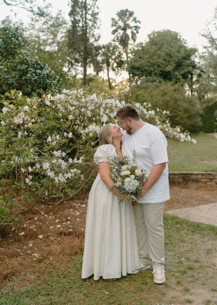 Couple holding a blue bouquet and excitedly smiling together. 