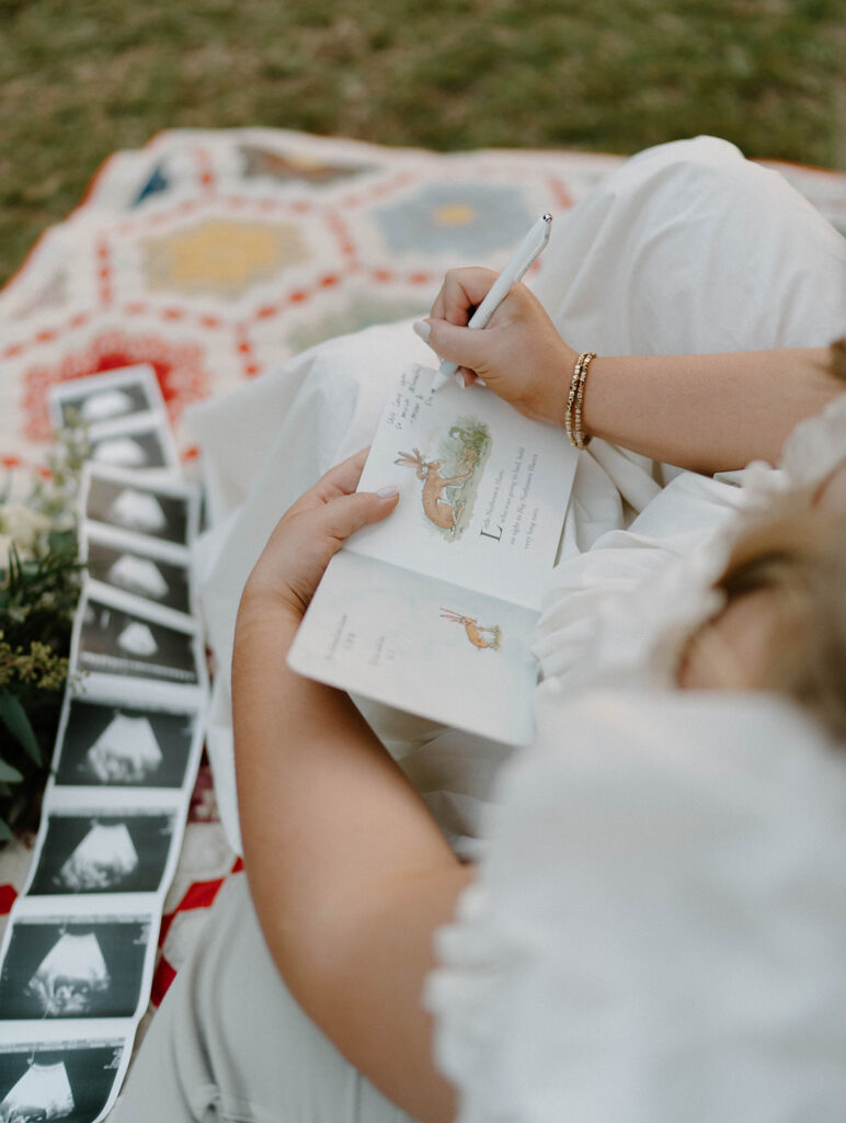 A woman writing a note in a children's book for her baby.