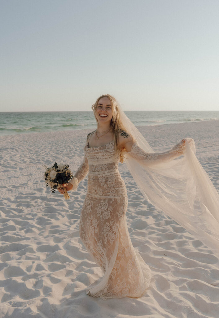 Bride holding her veil in the wind.