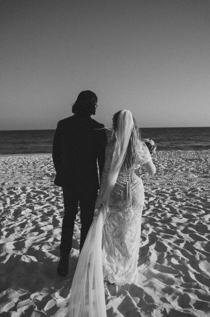 Bride and groom looking out into the ocean. 
