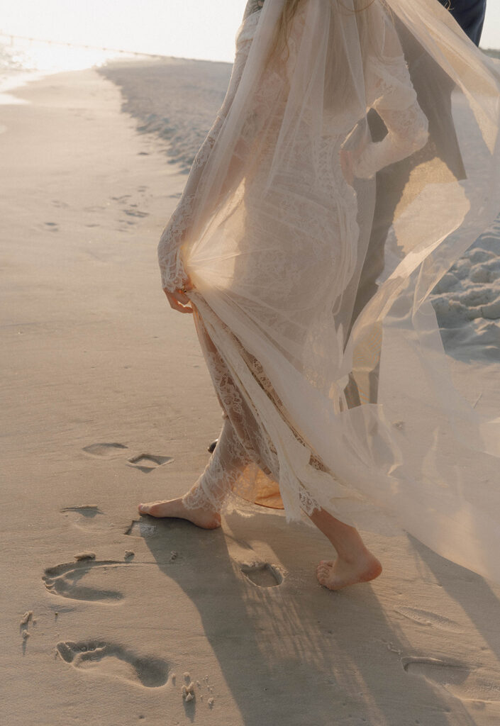 Bride and groom walking along the beach during their beach elopement.