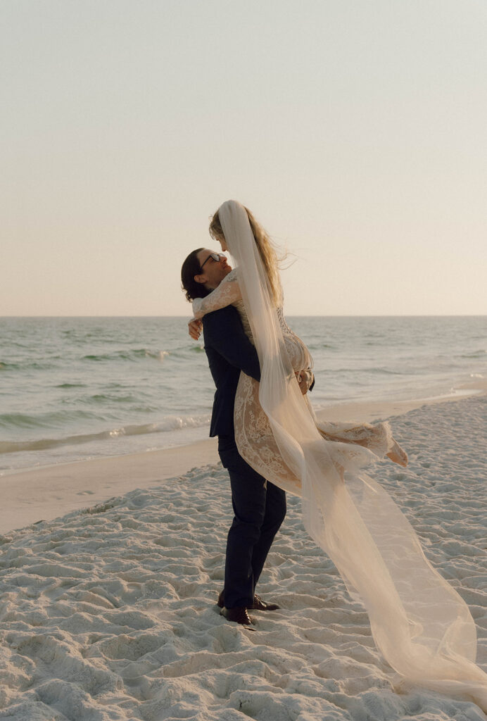 Groom holding his bride in the air.