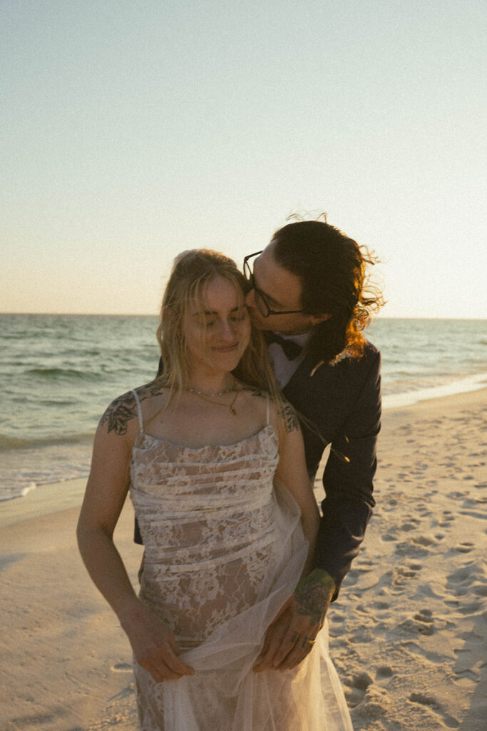 A groom holding his bride from behind at Fort Walton Beach.