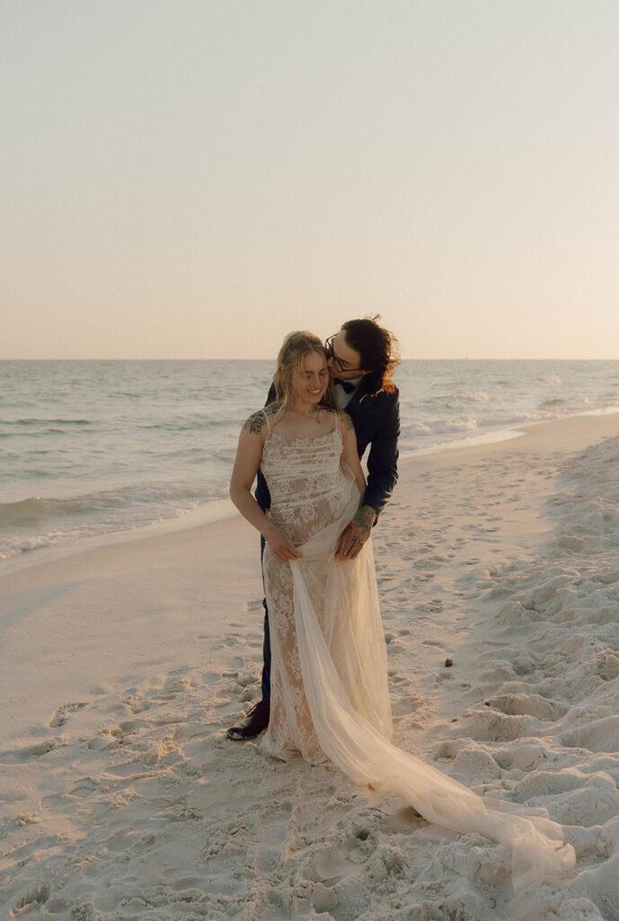 A groom kissing his wife's cheek.
