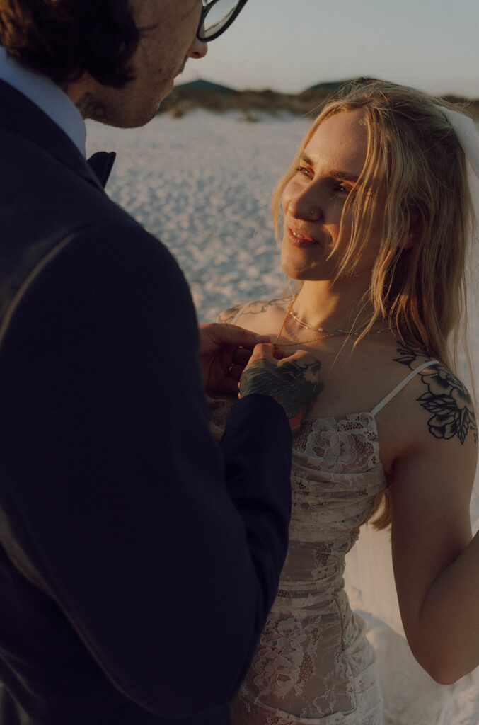 A groom holding his wife's necklace.