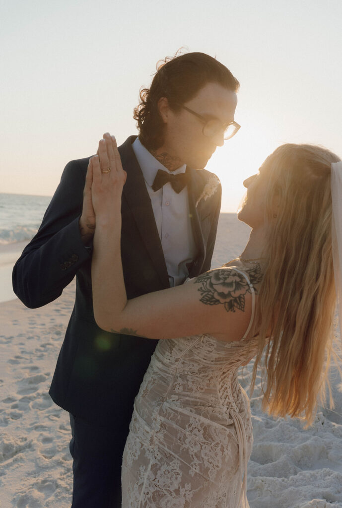 Bride and groom holding hands during sunset at their Fort Walton beach wedding.