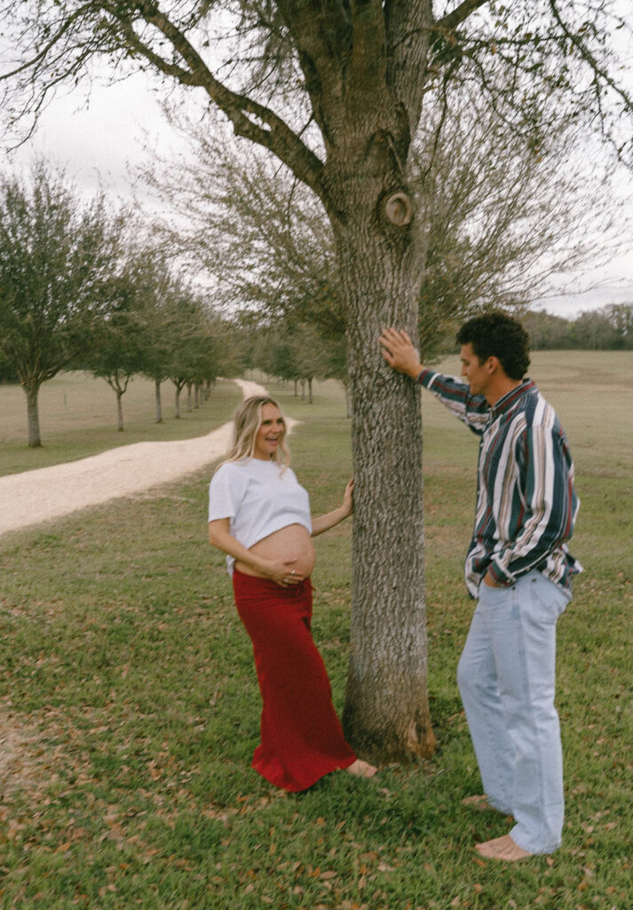 A couple leaning on a tree at J.R. Alford Greenway.
