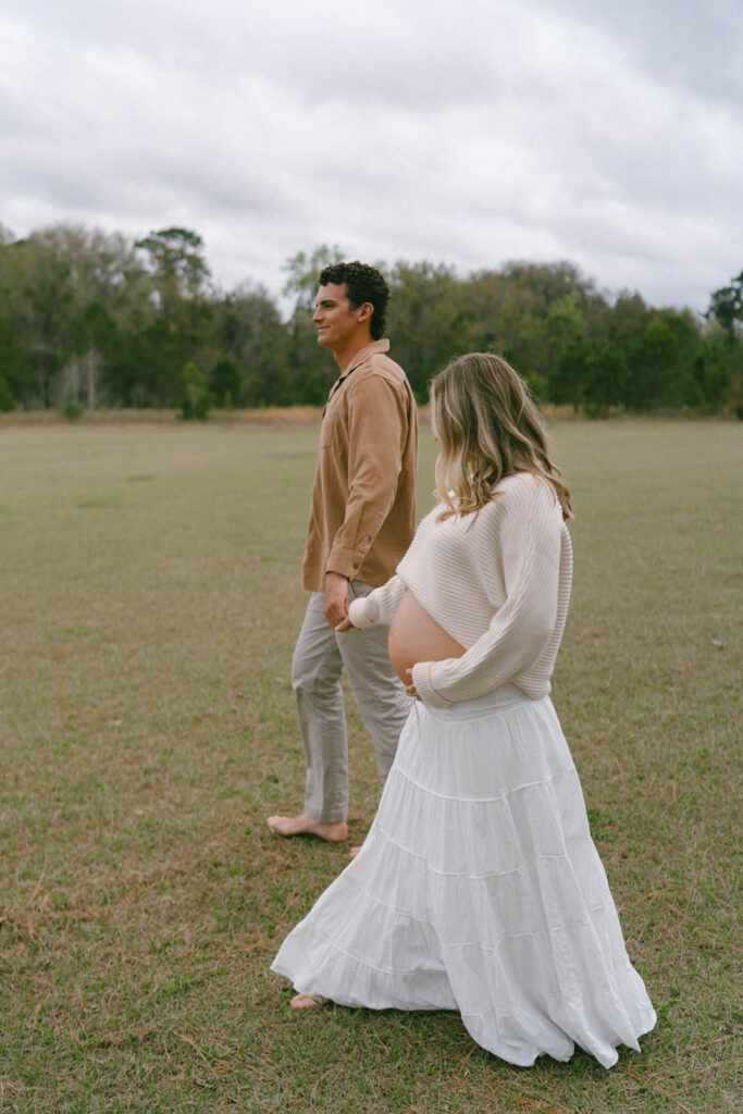 A couple walking and holding hands in a park in Tallahassee.