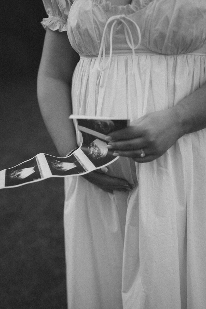 film photography maternity photoshoot with sonogram strip and picnic blanket