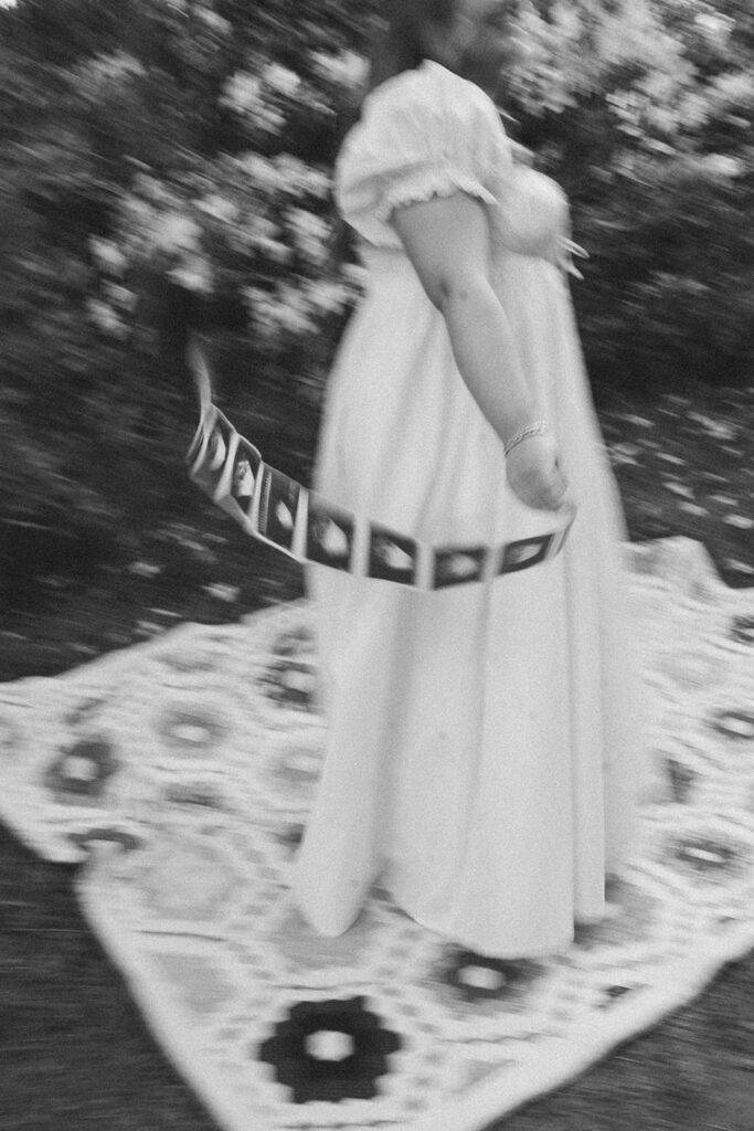 film photography maternity photoshoot with sonogram strip and picnic blanket