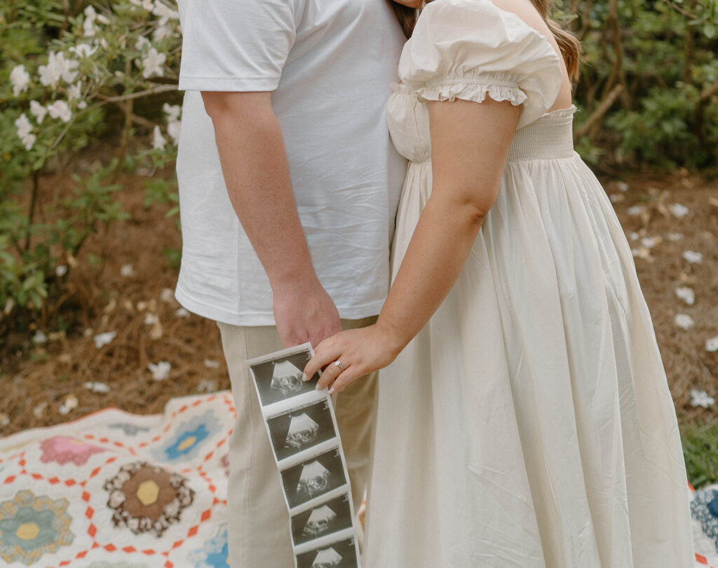 film photography maternity photoshoot with sonogram strip and picnic blanket