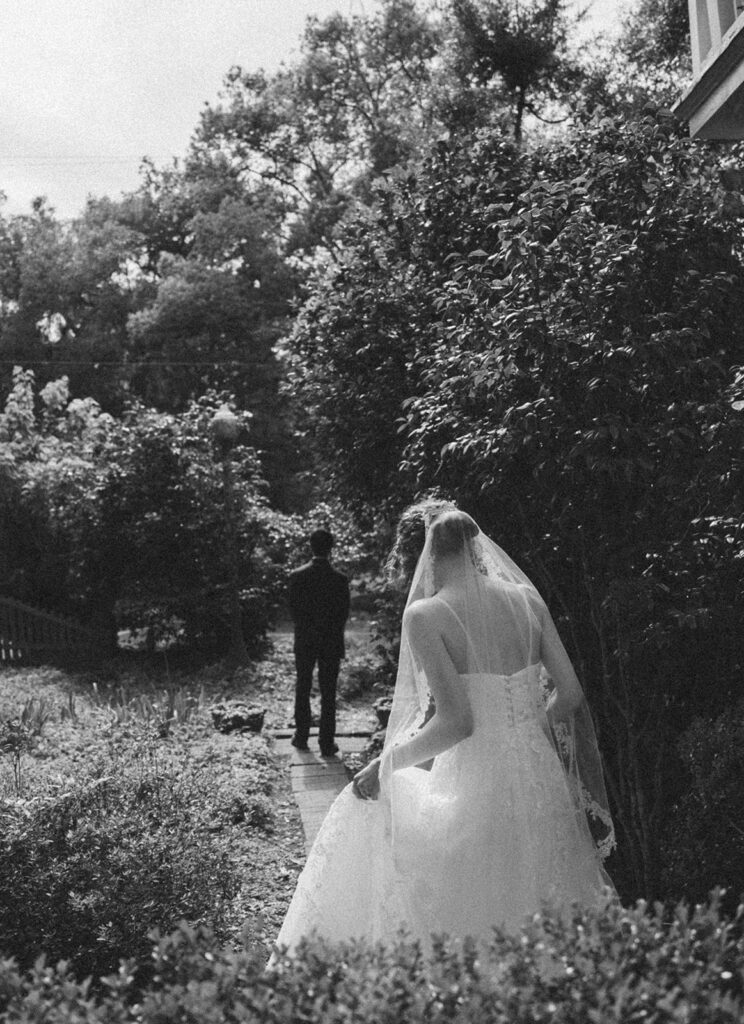 Bride walking towards her groom in the garden of the Monticello wedding venue. 