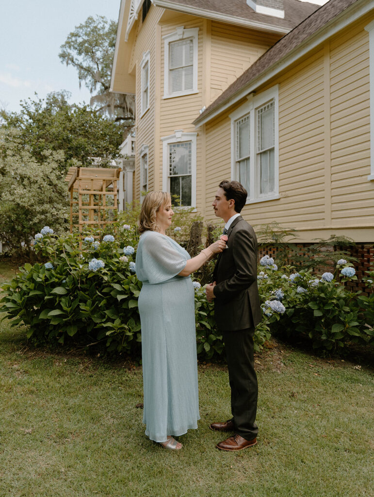 Mother of the groom adjusting his suit outside of The Avera-Clarke House.