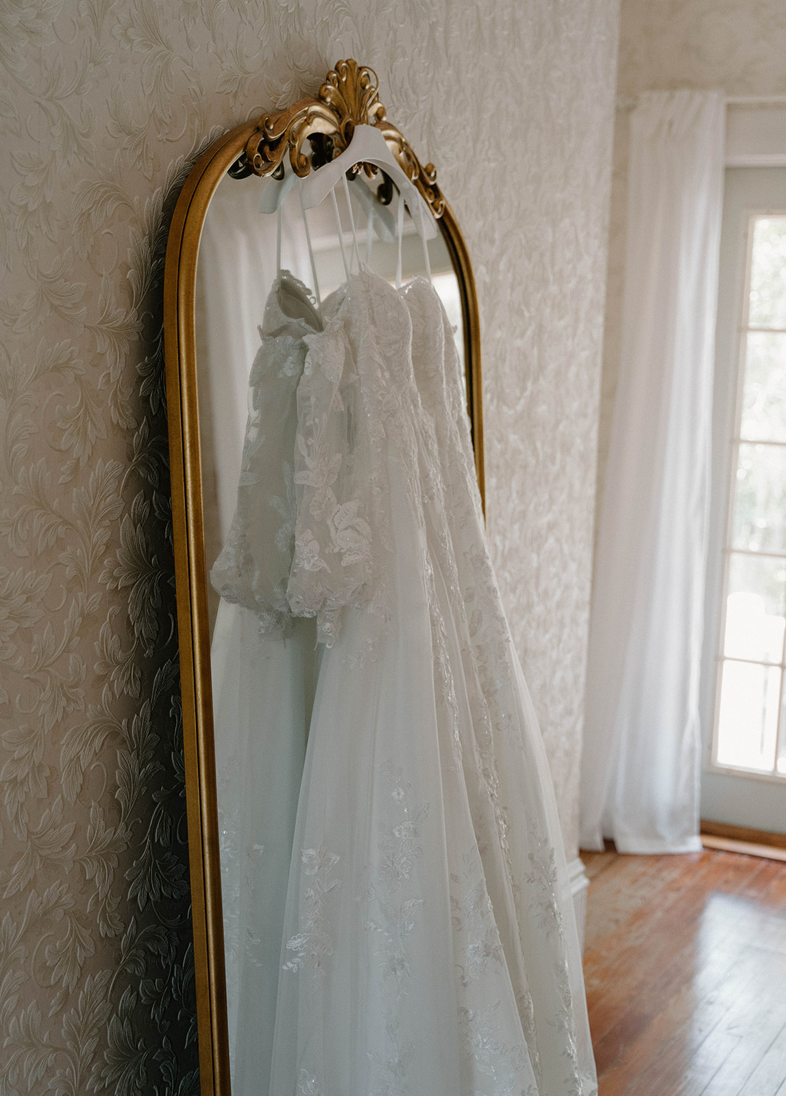 Wedding dress hanging on a gold mirror at The Avera-Clarke House.