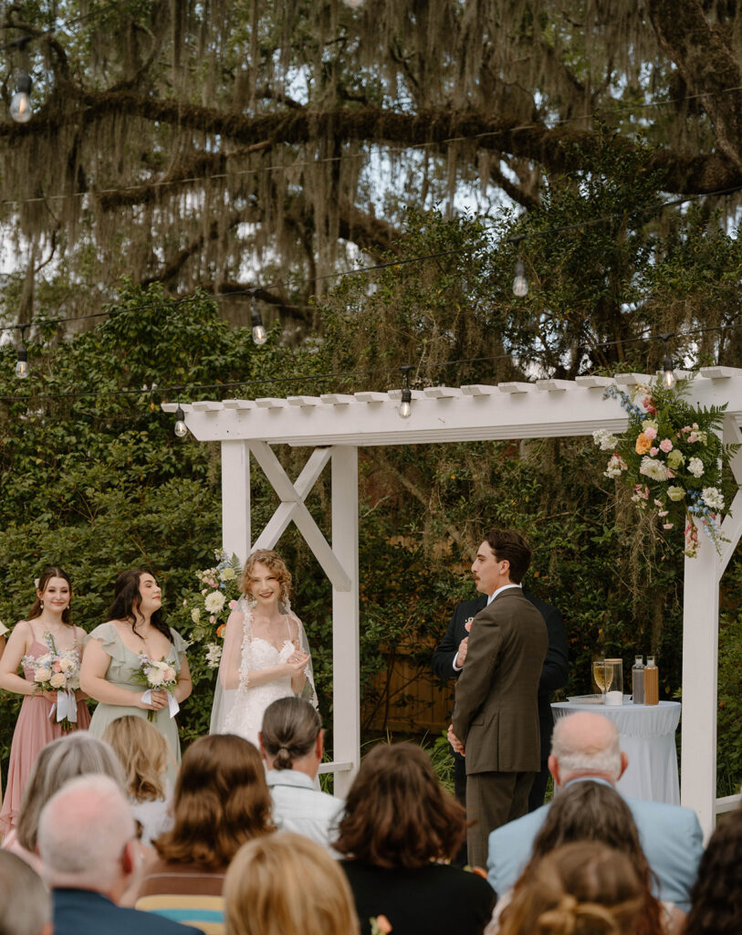 Bride and groom smiling at guests during the wedding ceremony. 