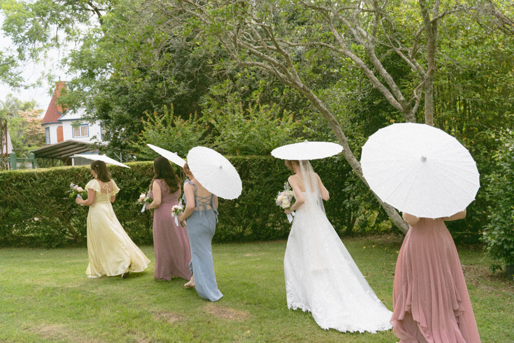 Wedding party holding parasols.