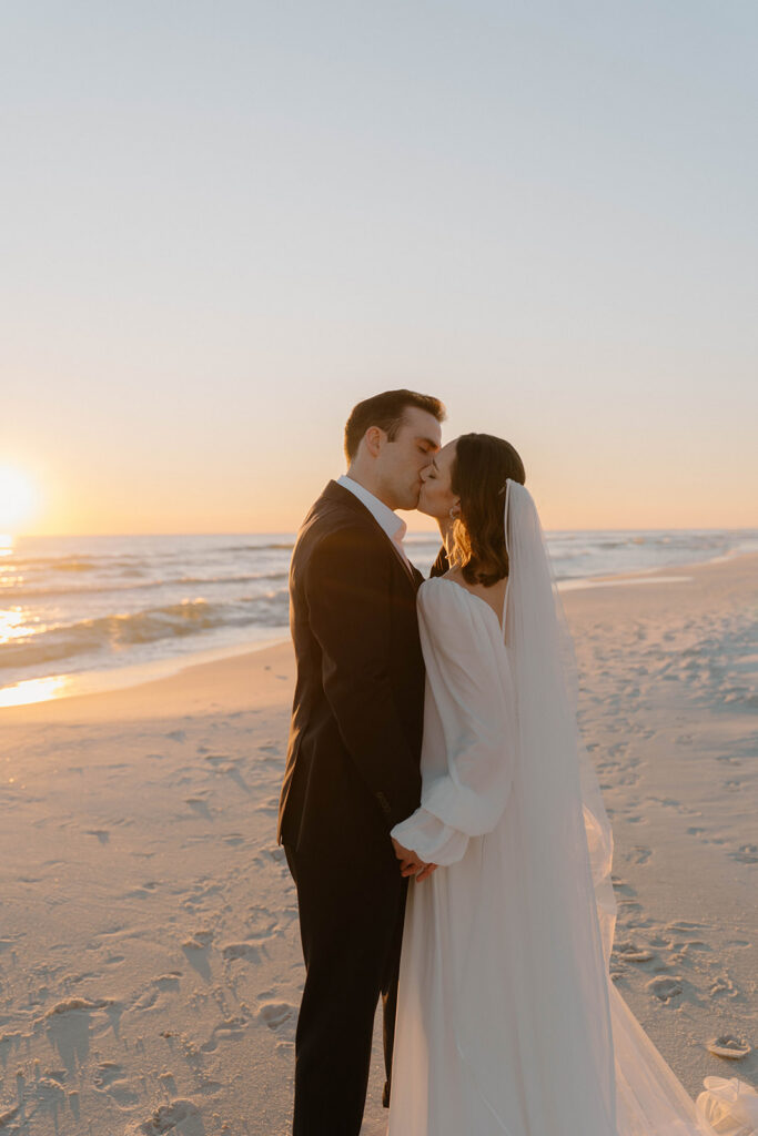 Bride and groom kissing during sunset.