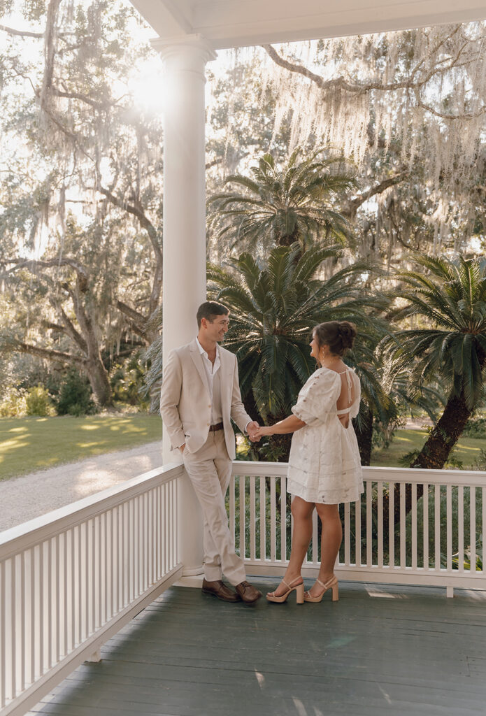 Bride and groom holding hands on the porch at Goodwood Museum & Gardens.