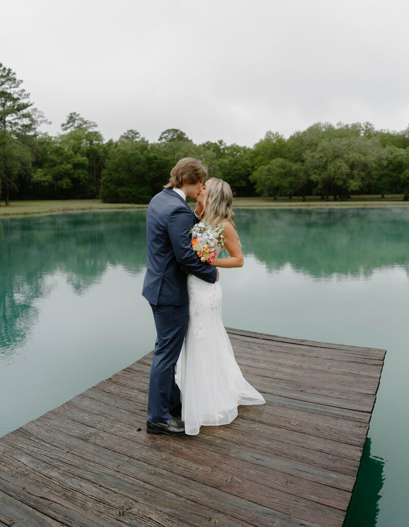 Bride and groom kissing on a dock at The Retreat at Bradley’s Pond.