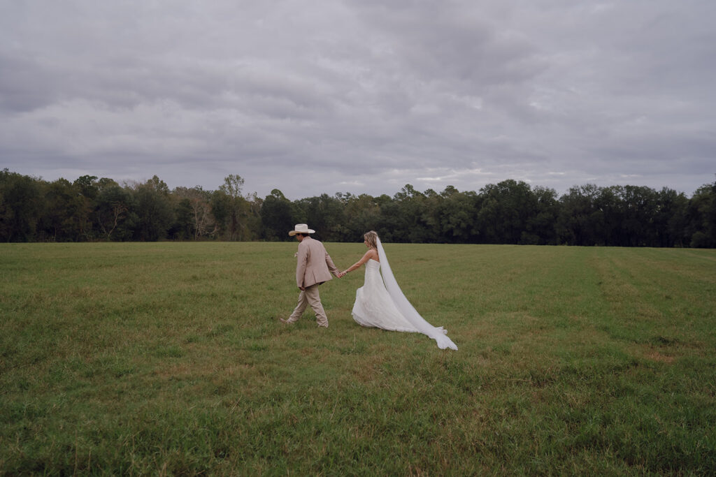 Bride and groom holding hands and walking outside at Woodberry.