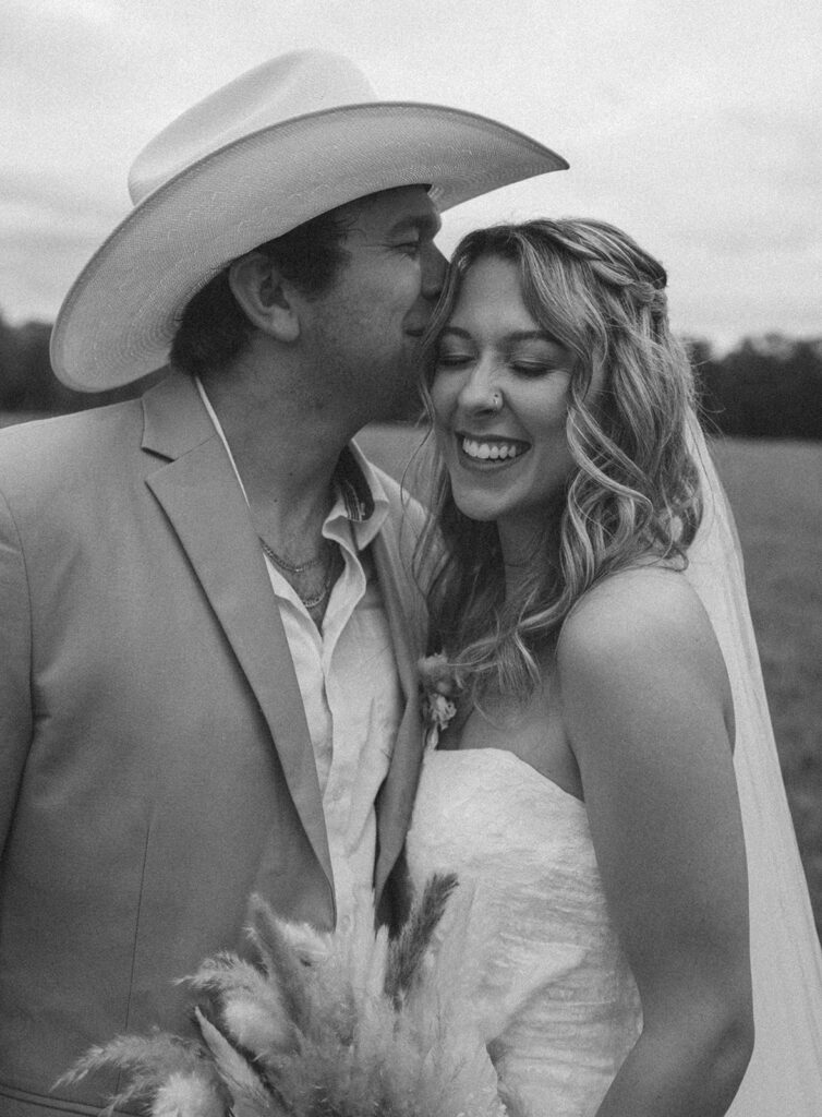 Groom kissing his bride outside at Woodberry.
