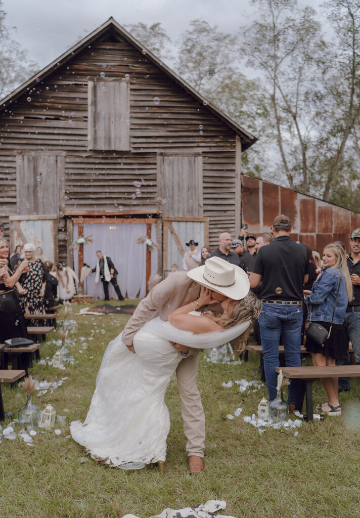 Bride and groom kissing during their wedding ceremony at Woodberry.