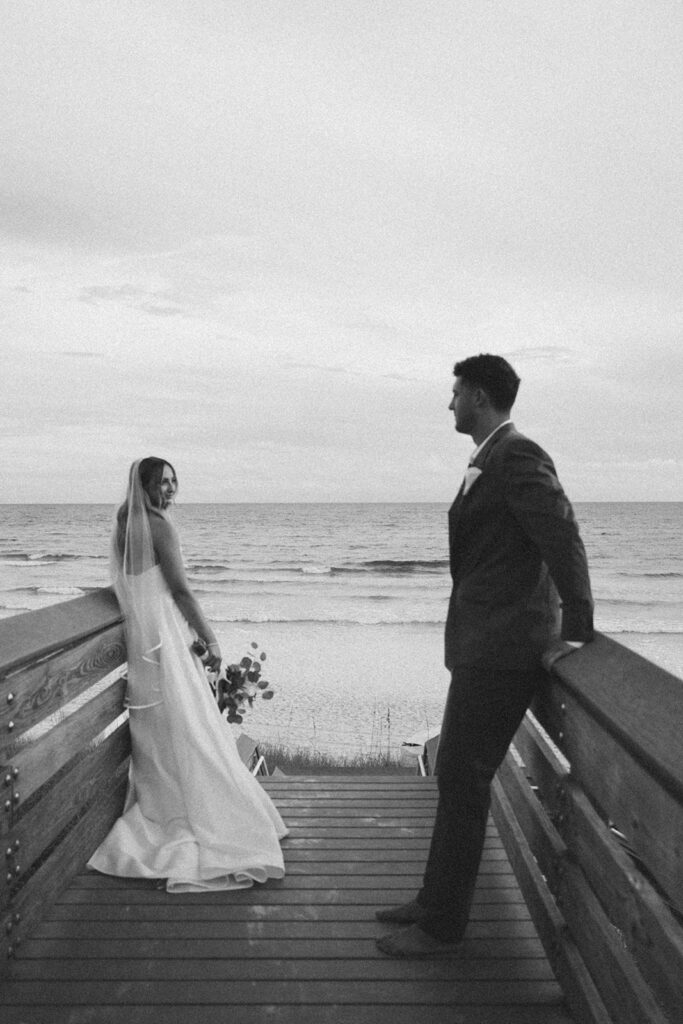 Bride and groom looking at one another on the dock at Santa Rosa Beach.
