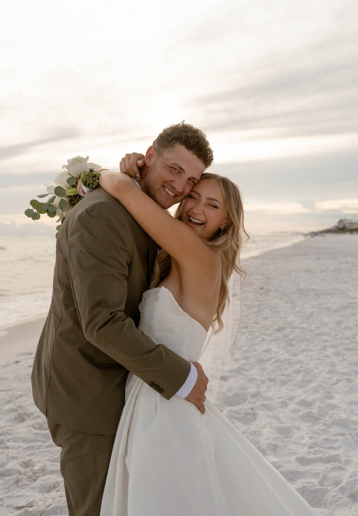 Bride and groom with their arms around one another, smiling at their Santa Rosa Beach wedding.