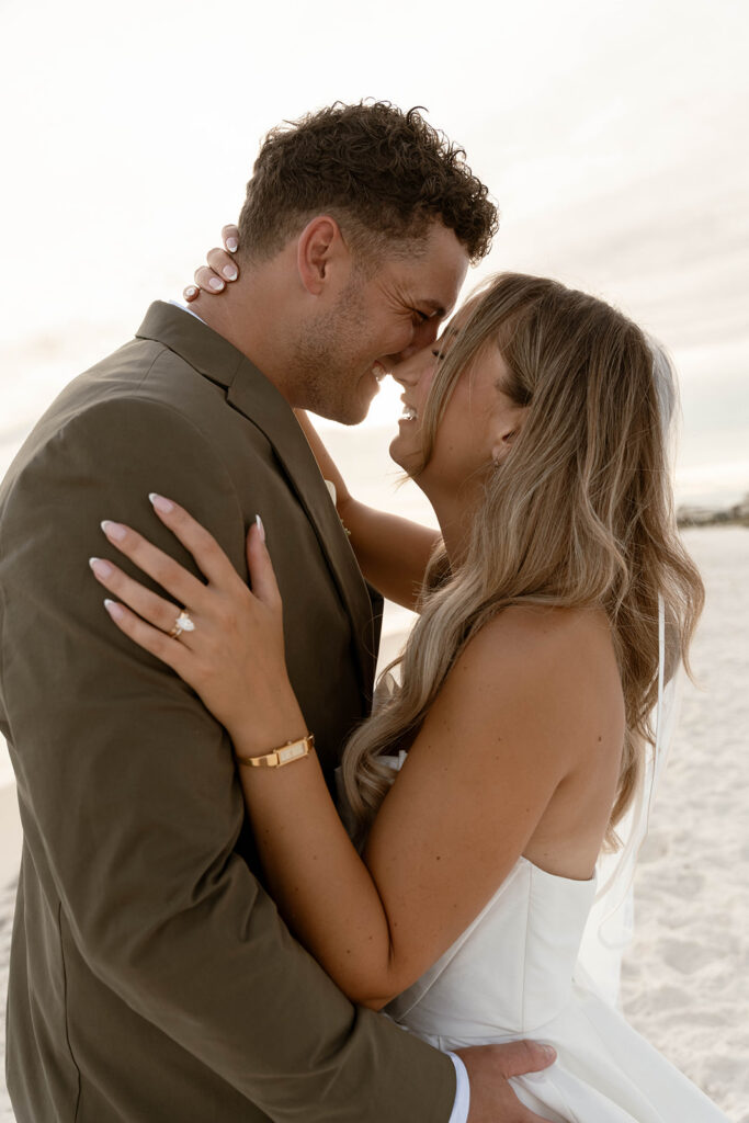 Couple kissing on the beach at their destination beach wedding.